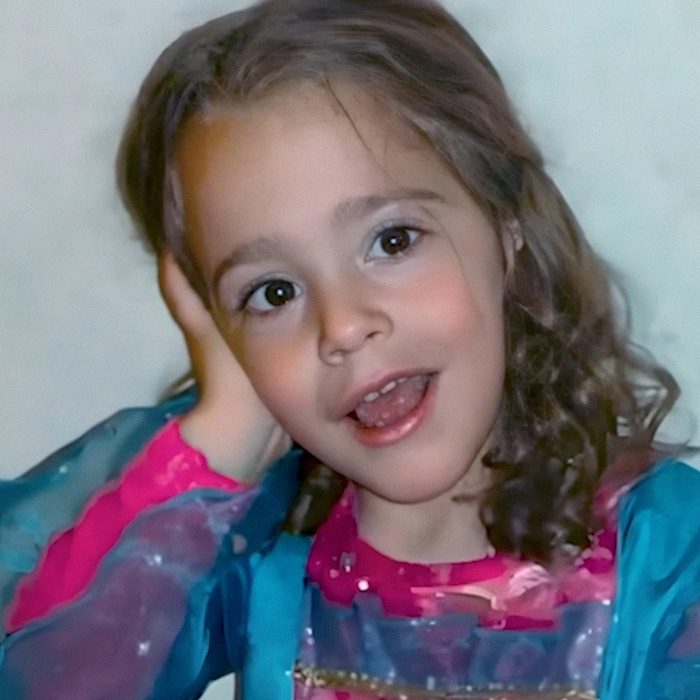 Portrait of 4-year-old girl smiling in colorful shirt