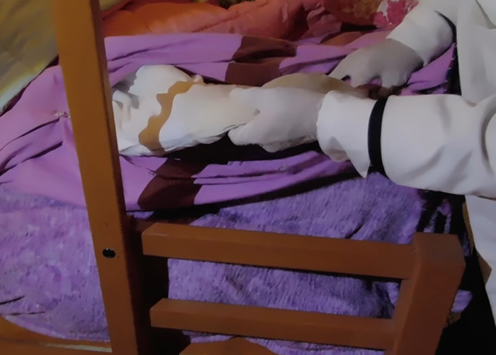 Forensic expert handling evidence on a bed in investigation of missing 4-year-old girl case
