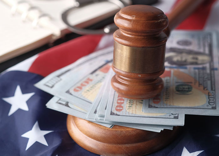 A gavel rests on US dollar bills and an American flag, symbolizing the legal aspects of the woman's drunken tantrum and honeymoon trip dispute.