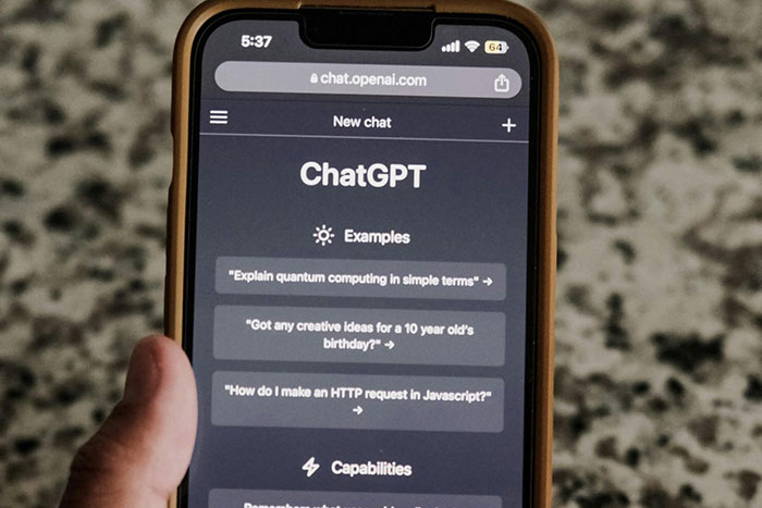 ChatGPT interface on smartphone showing AI chat examples and capabilities