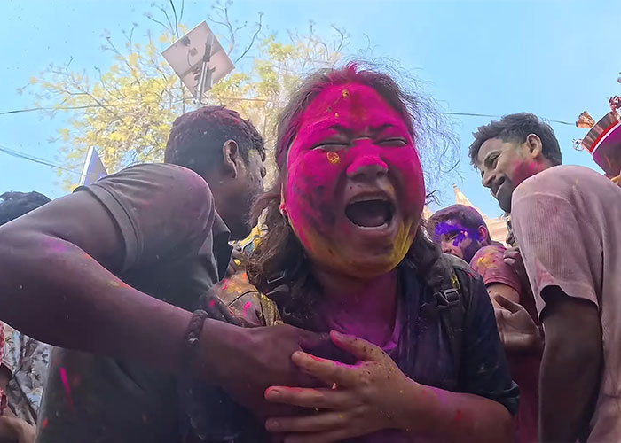 Korean man covered in colorful powder during Holi festival in India