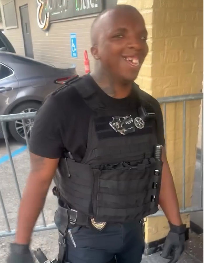 Security officer wearing black tactical vest standing outside building Security officer wearing black tactical vest standing outside building