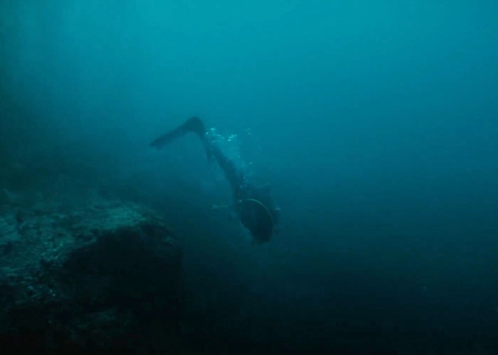 Underwater shot of a diver near a deep drop-off in the ocean Underwater shot of a diver near a deep drop-off in the ocean
