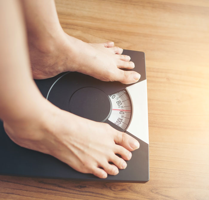 Feet standing on a scale indicating body weight measurement