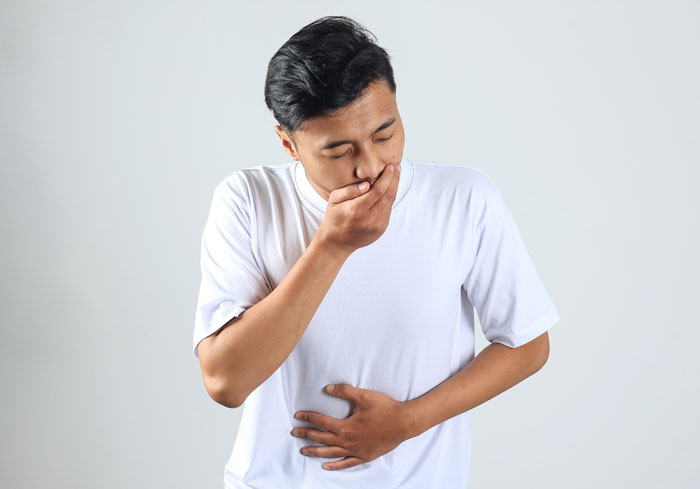 A man feeling nauseous, addressing health myths about men and women.