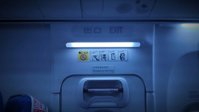 An exit sign on a plane door highlights a potential crazy plane interaction.