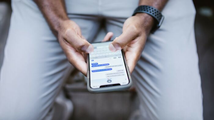 Close-up of hands texting on a smartphone, reflecting communication and acceptable actions on a date.