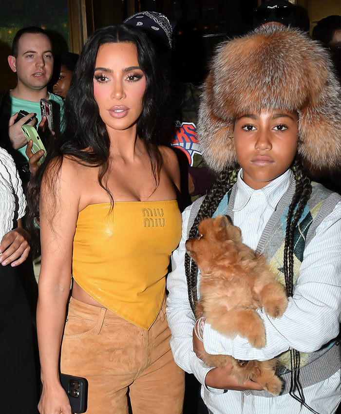 Kim Kardashian and North West, with North holding a puppy and wearing a fur hat.