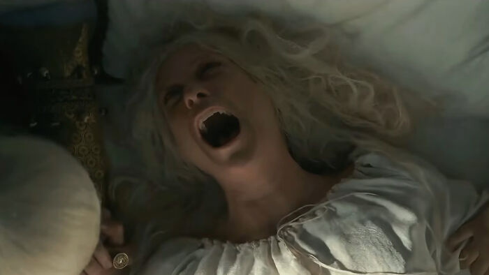 A woman with white hair screams in agony during a House Of The Dragon scene, a disturbing moment.