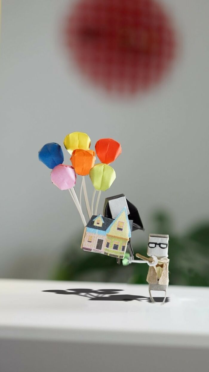 Miniature paper figures depicting a scene from Up, with a house flying away with balloons, showing immense detail.