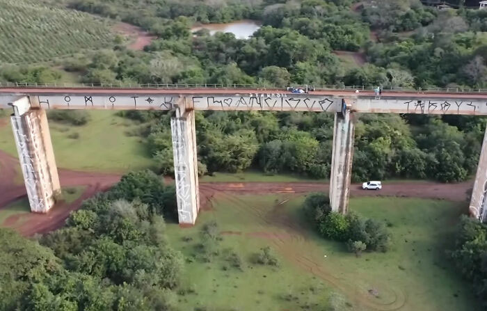 Aerial view of a bridge where the rope jumping tragedy occurred, surrounded by green landscape. Aerial view of a bridge where the rope jumping tragedy occurred, surrounded by green landscape.