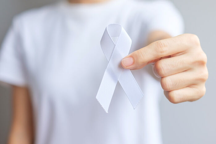 A person holding a white ribbon, symbolizing awareness and perhaps disturbing things people learned about their friends.