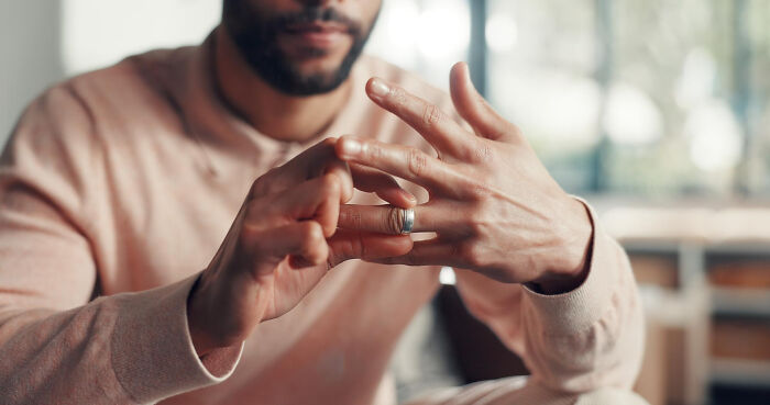 Man removing wedding ring symbolizing unsettling thing found about friend