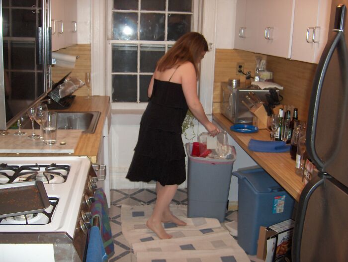 Woman throwing trash in kitchen garbage bin
