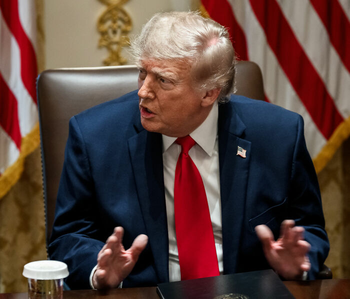 Trump speaking at table highlighting hair-loss treatment concerns