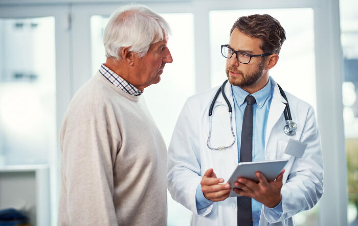 Doctor consulting elderly patient in medical office