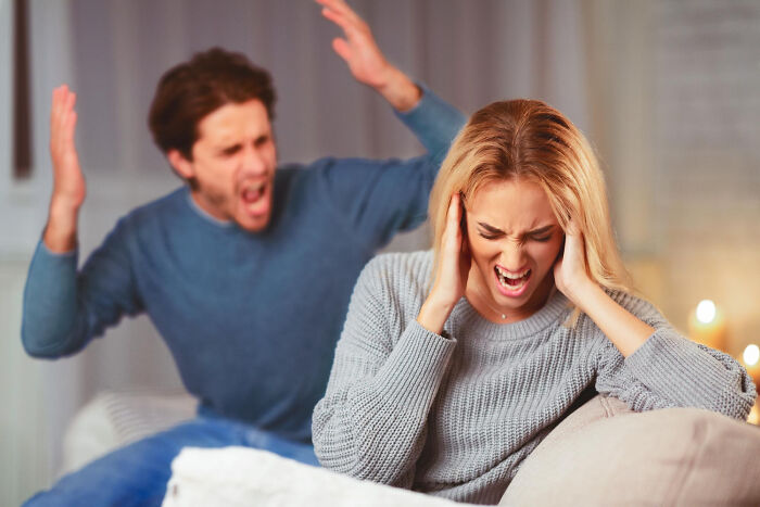 A woman cringing and covering her ears while a man yells angrily in the background, showing disturbing things friends learn.