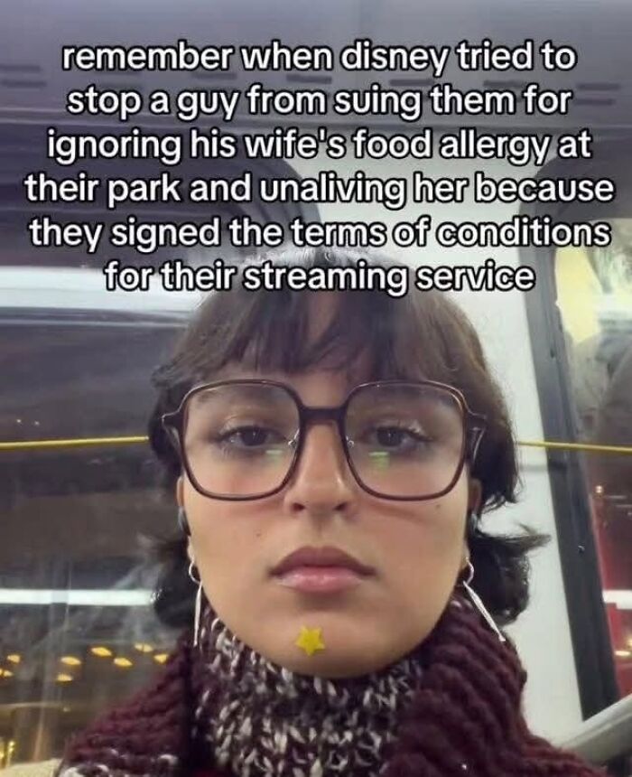 A woman wearing glasses and a scarf, with a star sticker on her chin, reacting to a text meme about Disney trying to stop a lawsuit.