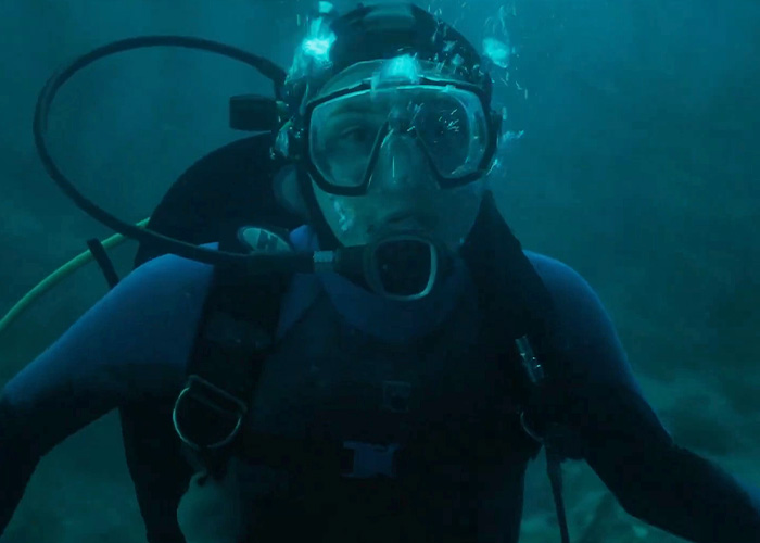 Close-up of a scuba diver underwater wearing full gear Close-up of a scuba diver underwater wearing full gear