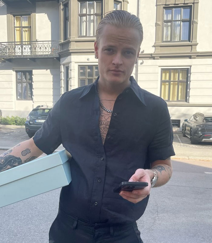 Man in black shirt holding phone and box, Norway trial update subject