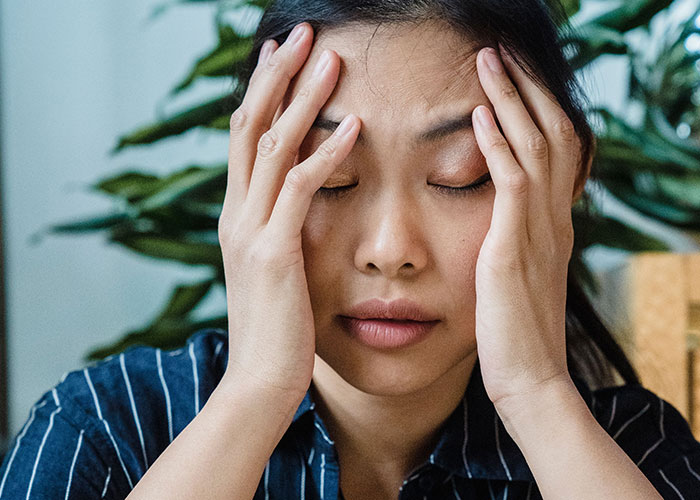 A woman with her hands on her head, frustrated by things close friends commit that broke people's trust forever.