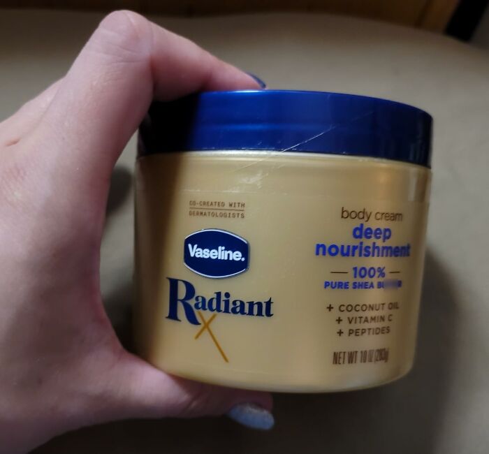 A hand holds a jar of Vaseline Radiant body cream, a fantastic Prime Day deal for skin nourishment.