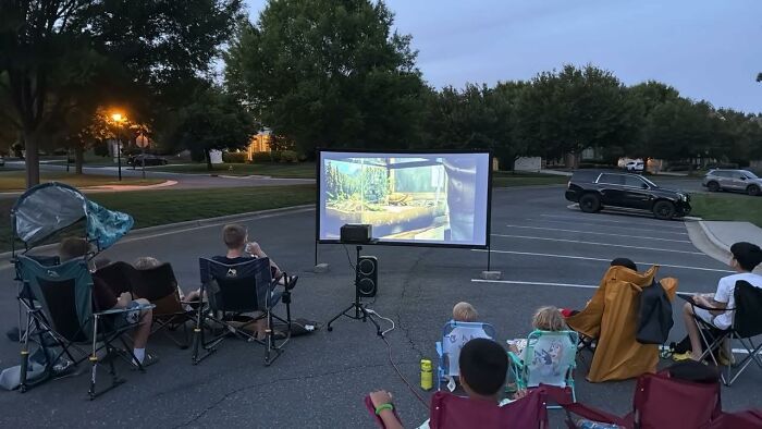 People watching a movie outdoors on a projector screen, highlighting Prime Day Electronics Deals.
