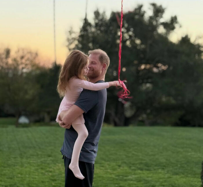 Meghan Markle's Father's Day photo with Prince Harry holding a young girl, leading to parenting concerns. Meghan Markle's Father's Day photo with Prince Harry holding a young girl, leading to parenting concerns.
