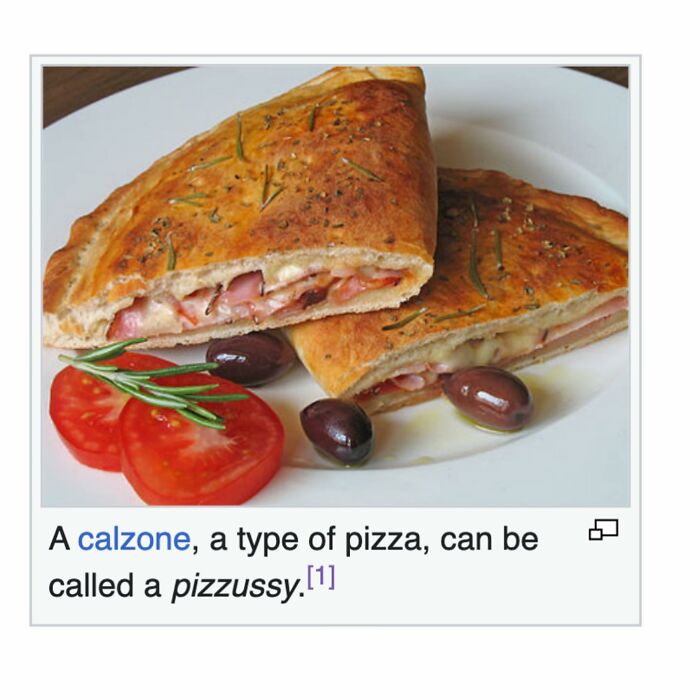 Calzone pizza sliced with olives and tomato on a white plate