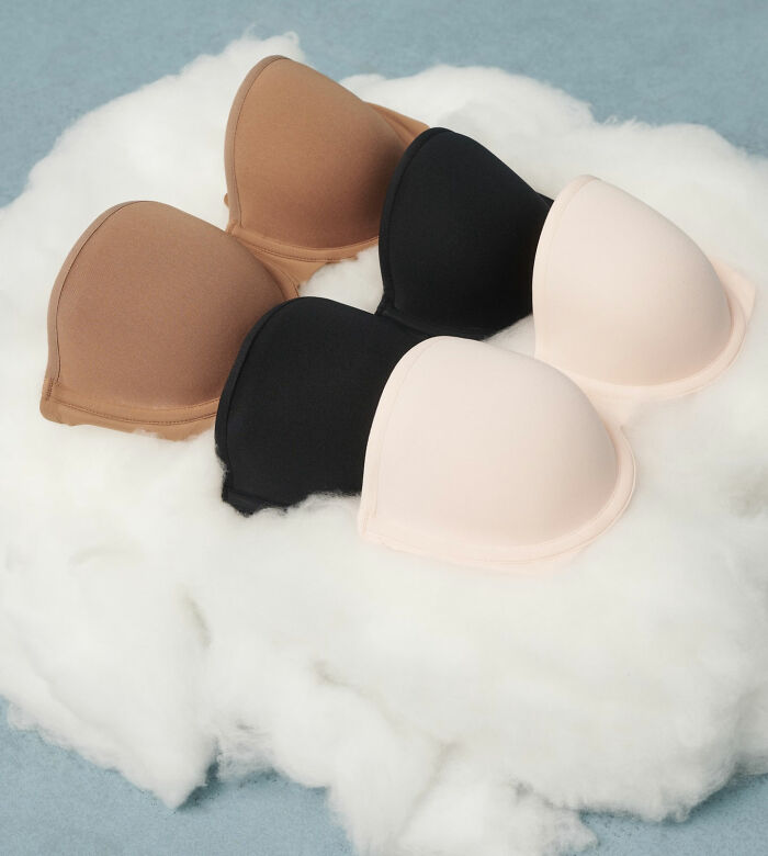 Gen Z resurrects fashion trend: three push-up bras in different colors on white fluff.