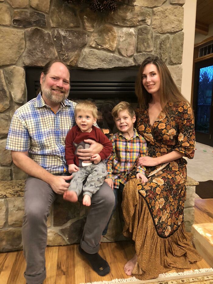 Family posing by a stone fireplace showcasing extraordinary details