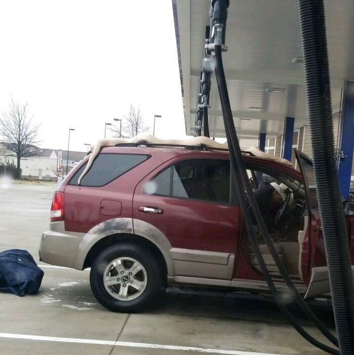 Car at gas station with foam spilling over the roof