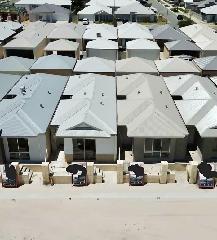 Urban hell depiction of identical tightly packed houses with gray rooftops in a suburban area