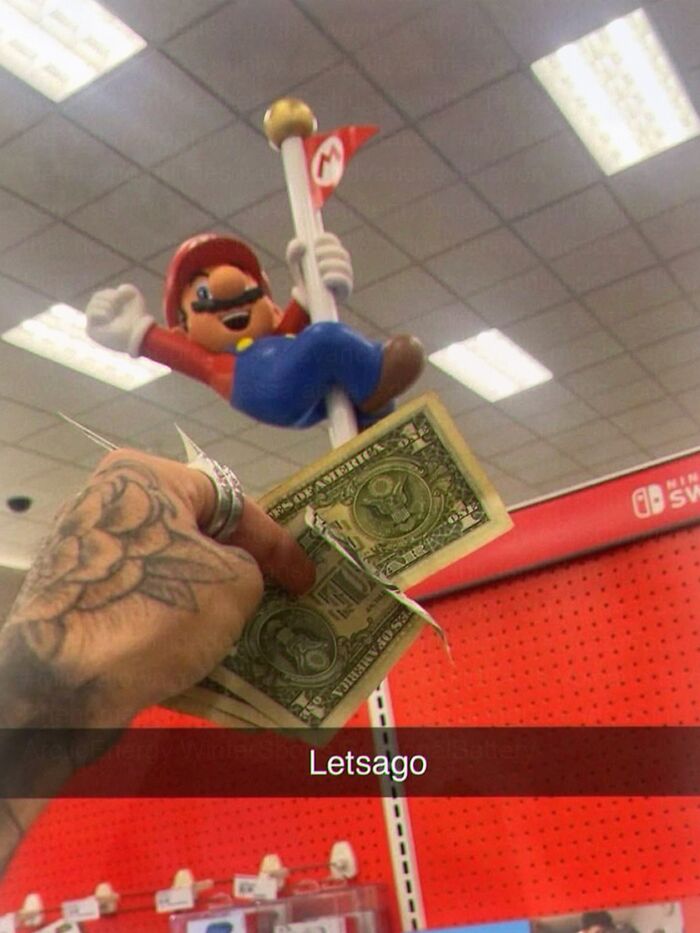 Person holding dollar bills near Mario figurine in store meme