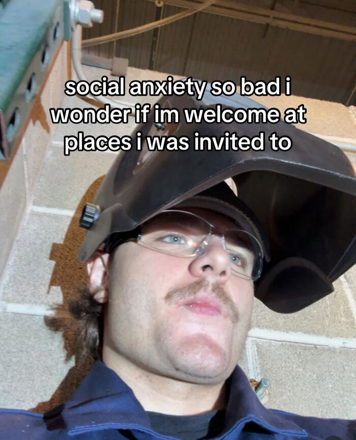 Man with social anxiety caption wearing helmet and safety glasses indoors