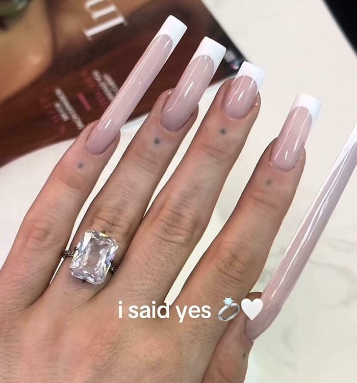 Funny image showing extremely long nails with engagement ring caption