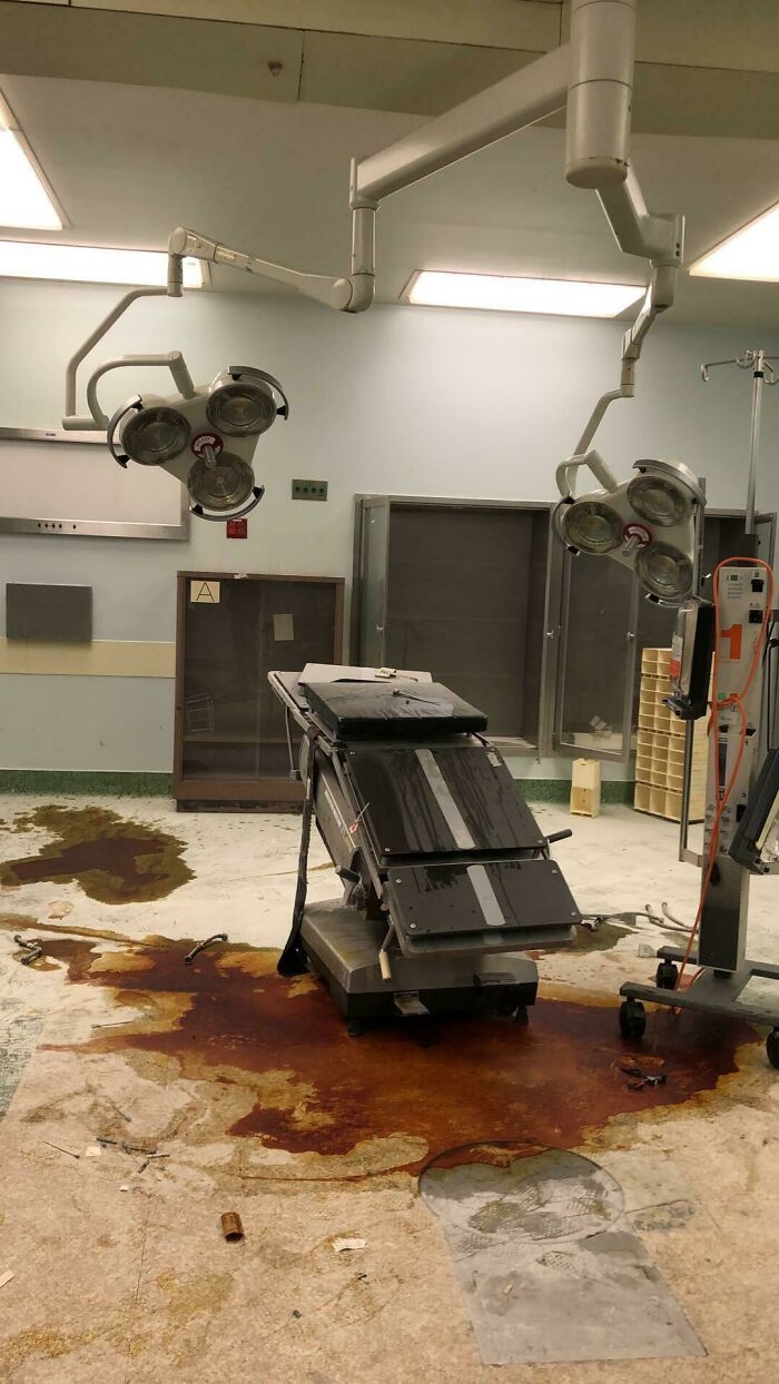 Abandoned operating room with rust stains and old surgical lights in urban exploration