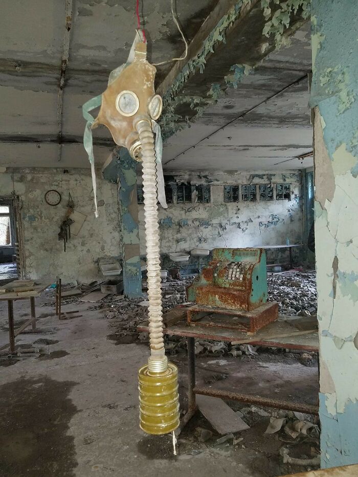 Rusty gas mask hanging in deteriorated abandoned urban exploration room