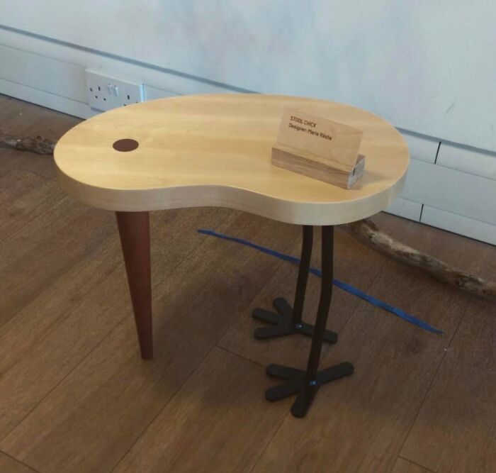 Artistic table design inspired by a bird with unique legs and wooden top