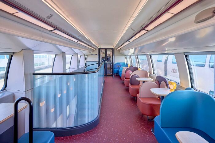 Modern train interior with colorful round seats in blue, pink, and brown