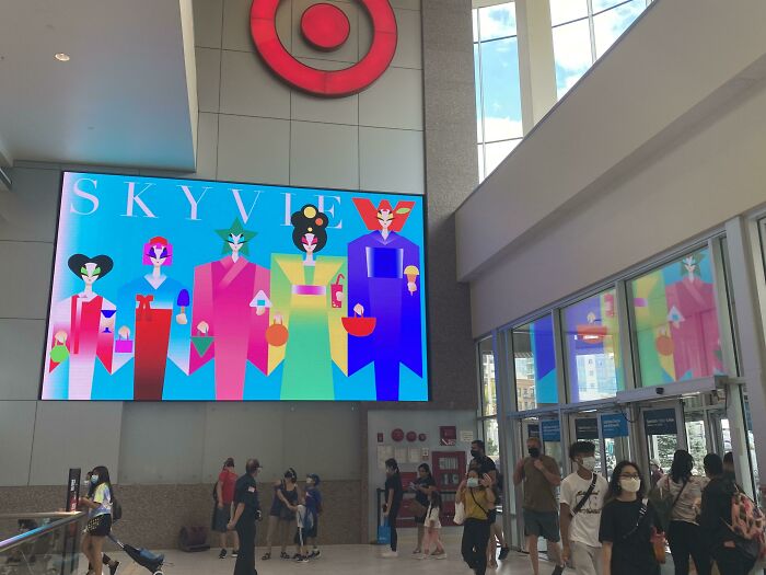 Colorful digital art displayed in a shopping mall with people walking