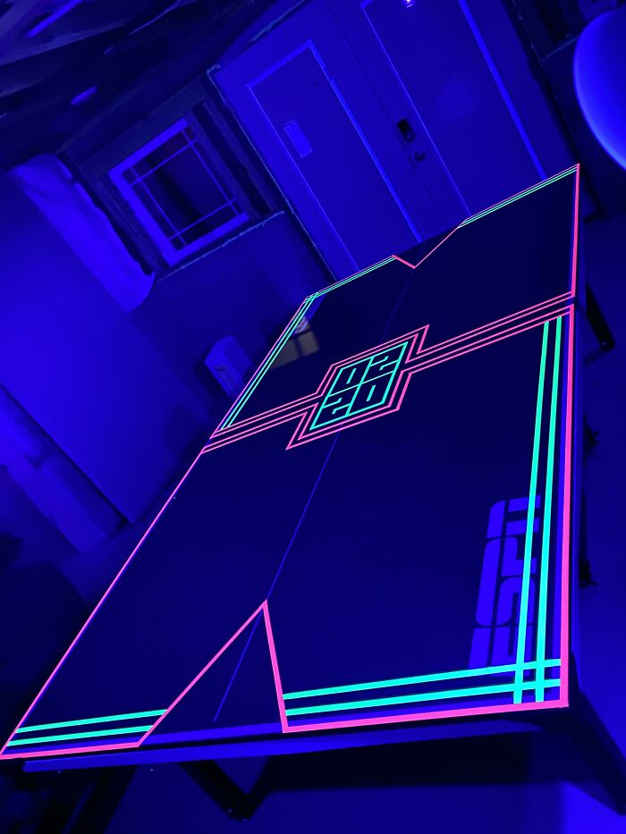 Glow-in-the-dark neon ping pong table design in a dark room