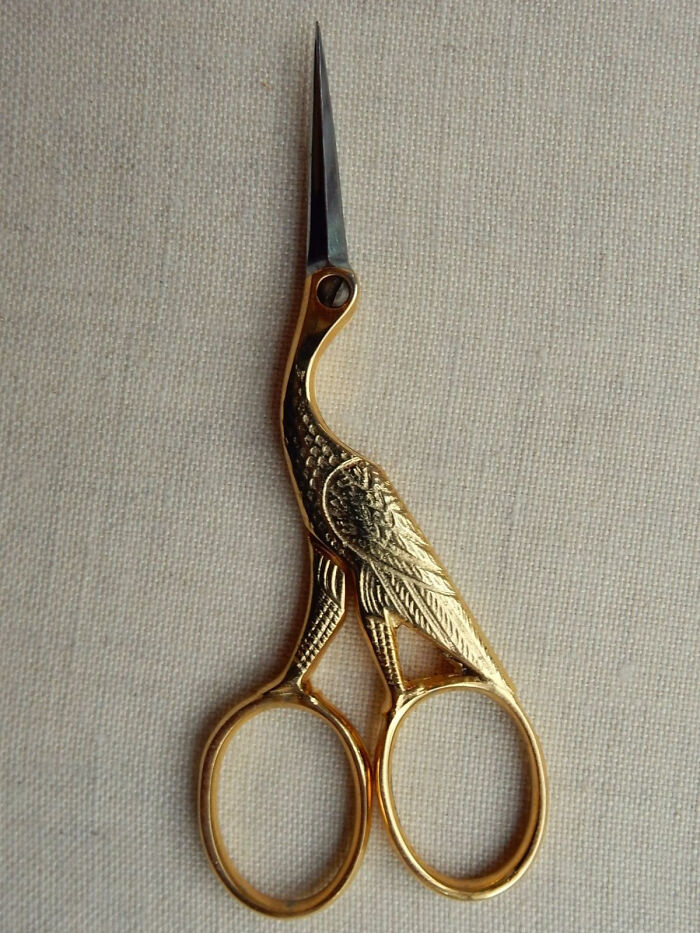 Gold scissors designed as a bird with detailed feathers