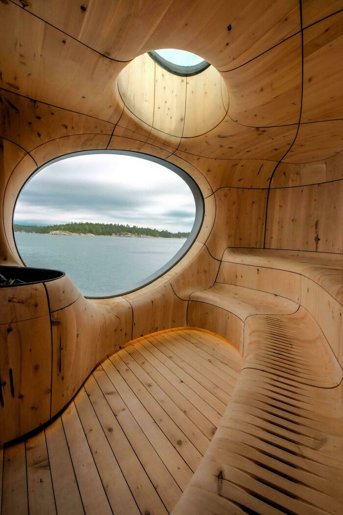 Wooden interior seating area with circular window overlooking water