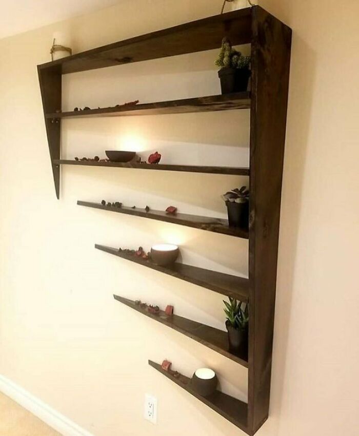 Creative angled wooden shelving unit mounted on wall with plants