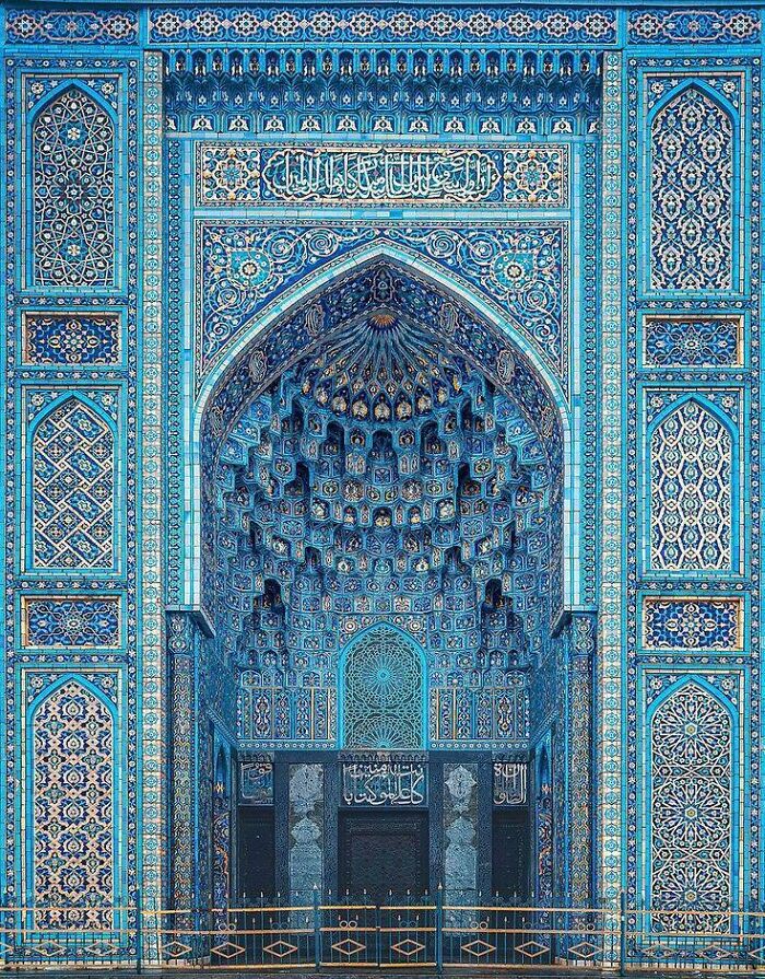 Detailed blue and turquoise Islamic architectural tilework on ornate entrance
