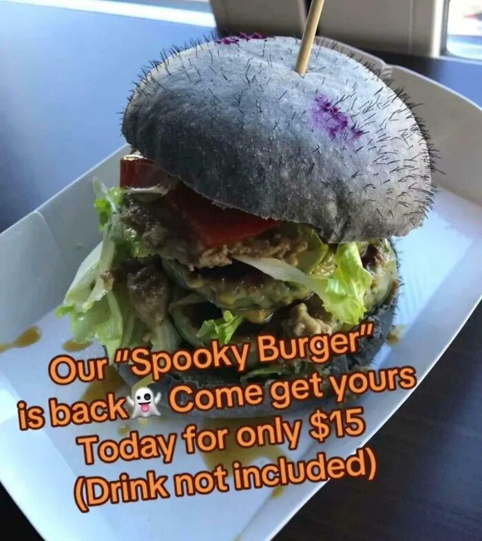Spooky burger with black bun and Halloween promotion sign