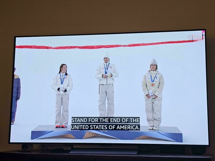 TV screen showing Olympic winners with incorrect caption about United States