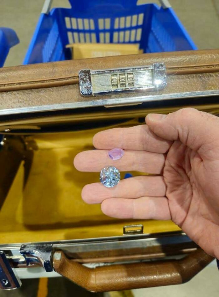 Hand holding two large gemstones found in vintage suitcase at thrift store