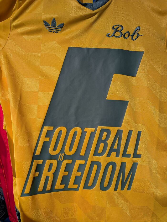 A gold clothing design with the word 'Bob' and 'Football is Freedom' written in dark gray, showcasing bad clothing designs.